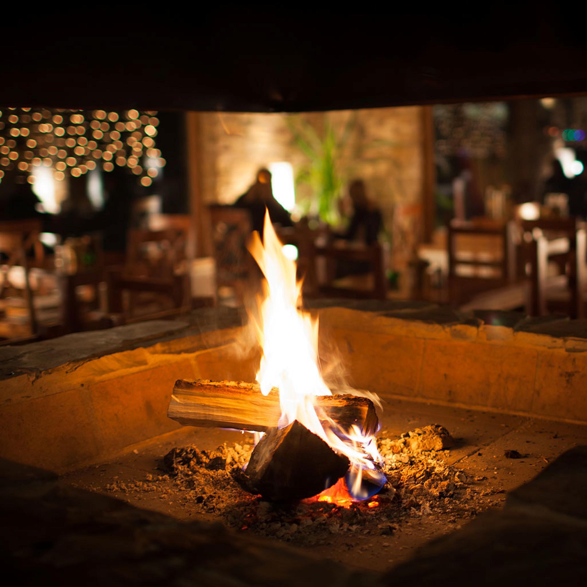 A fire in a square outdoor fire pit. 